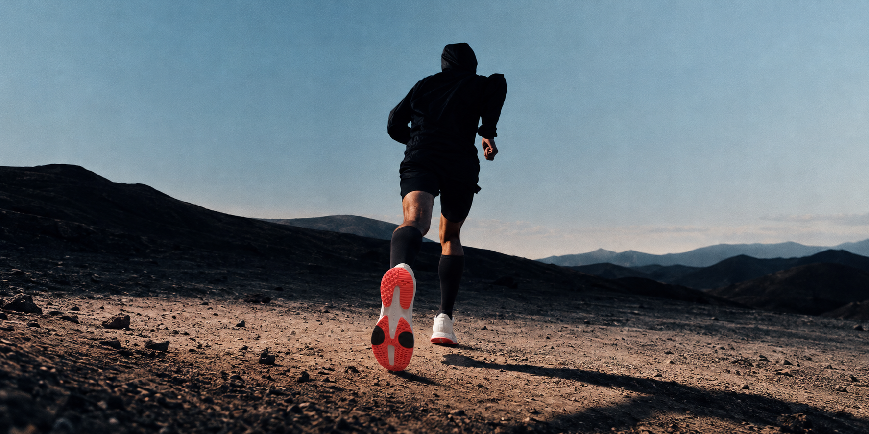 Runner crossing a rugged hillside